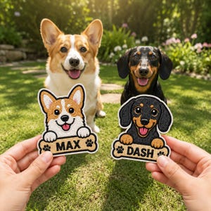 May include: Two embroidered patches featuring cartoon dog portraits. The left patch shows a tan and white Corgi with the name MAX on a bone-shaped base. The right patch shows a black and tan Dachshund with the name DASH on a bone-shaped base.