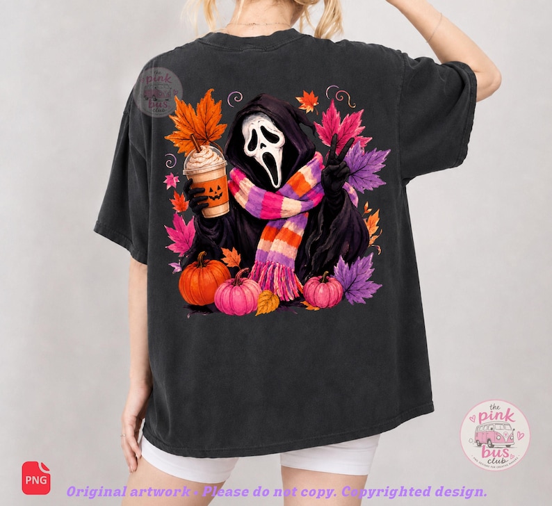 May include: A black short-sleeve t-shirt featuring a graphic of a hooded figure with a white mask, wearing a striped scarf, holding a pumpkin-faced coffee cup, and making a peace sign, surrounded by colorful autumn leaves and orange pumpkins.
