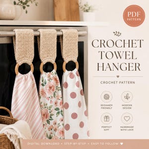 Op de afbeelding: Drie gehaakte handdoekhangers met beige gehaakte bovenkanten bevestigd aan houten ringen, met handdoeken met roze gestreepte, bloemrijke en stippenpatronen. De afbeelding bevat de tekst CROCHET TOWEL HANGER en PDF PATTERN.