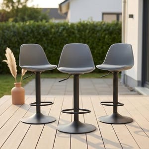 May include: Three gray bar stools with smooth, rounded seats and backrests. Each stool features a matte black central pedestal base, a circular floor plate, and a matching black footrest ring. A small lever is visible under each seat.