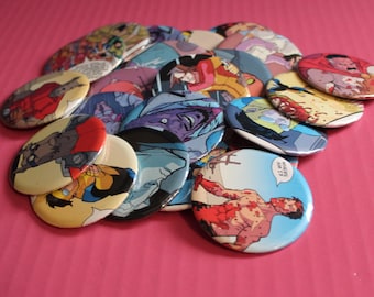 May include: A collection of colorful, oval-shaped buttons featuring comic book art. The buttons display various characters and scenes, with vibrant colors and detailed illustrations. The buttons are scattered on a pink surface.