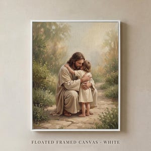 May include: A white floated framed canvas print featuring a painting of a long-haired figure in a beige robe kneeling to embrace a small child in a light-colored tunic on a stone path surrounded by soft-toned trees and greenery.