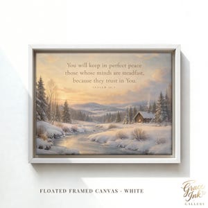 May include: A rectangular canvas print in a white floating frame featuring a winter landscape with a snow-covered cabin, a winding stream, and pine trees under a sunset sky. The text reads: You will keep in perfect peace those whose minds are steadfast, because they trust in You. ISAIAH 26:3.