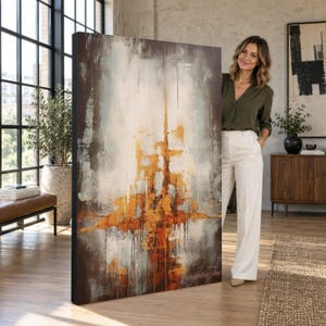 May include: A large rectangular canvas painting featuring an abstract composition with vertical streaks of metallic gold, burnt orange, and deep brown layered over a textured white and light gray background with visible paint drips.