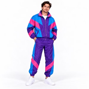 May include: A matching tracksuit set featuring a zip-up jacket and trousers in a vibrant color-blocked pattern of purple, bright blue, and hot pink. The jacket has a high collar and long sleeves, while the trousers have an elasticated waist.