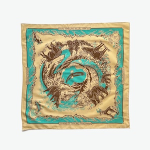 Peut inclure: Un bandana jaune avec une bordure turquoise repr&eacute;sentant un motif circulaire d'animaux et de plantes. Le texte "Grand Teton National Park" est imprim&eacute; en bas du bandana.