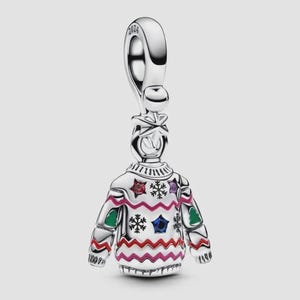 May include: A silver charm shaped like a jumper with a festive pattern, featuring red, green, blue, and purple enamel accents in star and snowflake shapes. The bail at the top is engraved with the year 2024, and the piece has a polished finish.