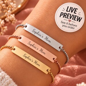 Könnte beinhalten: Drei verstellbare Kettenarmbänder mit rechteckigen Metallstegen in Silber-, Roségold- und Goldtönen. Jeder Steg ist mit dem Text Sophia's Mom in Schreibschrift graviert. Ein runder Aufkleber mit dem Text LIVE PREVIEW See it before you order.