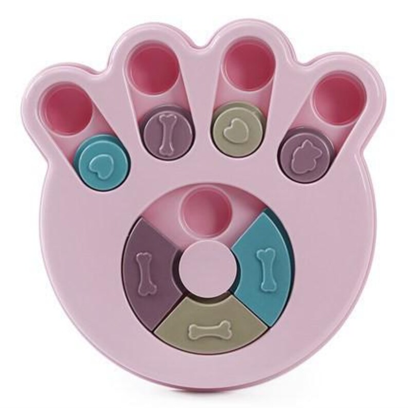 May include: A pink paw-shaped dog puzzle toy with multiple compartments and sliding pieces. The toy features various shapes and colours, including bone and heart designs, designed to stimulate a pet's mind and provide a fun challenge.