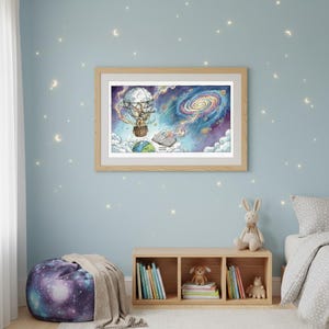 May include: A framed print shows a fantastical scene of a hot air balloon with a person inside, heading towards a galaxy. The artwork uses vibrant colours, including blues, purples, and yellows, with a detailed illustration of the Earth and an open book.