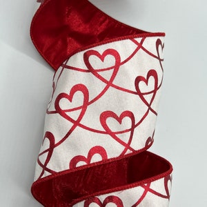 May include: White satin ribbon with a red satin edge and a repeating pattern of red hearts.