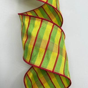 May include: Green, yellow, and red striped ribbon with a red edge. The ribbon is woven with a plaid pattern.