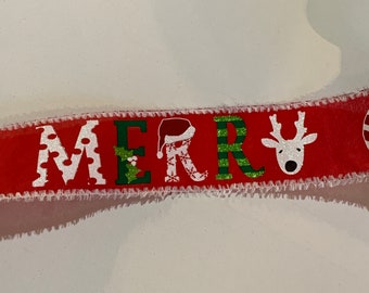 May include: Red ribbon with white text that reads "MERRY" with Christmas-themed designs. The ribbon has a white, frayed edge. The letters are decorated with a Santa hat, snowflakes, and a reindeer.