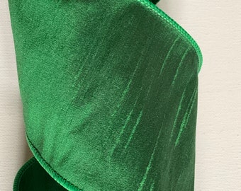 May include: A roll of green satin ribbon with a wired edge. The ribbon has a subtle shimmer and a textured pattern.
