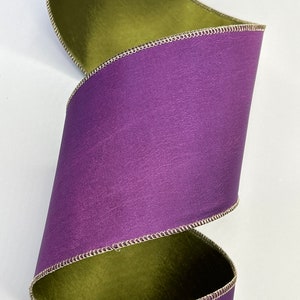 May include: Purple and green double-sided satin ribbon with a gold edge. The ribbon is folded in a spiral.