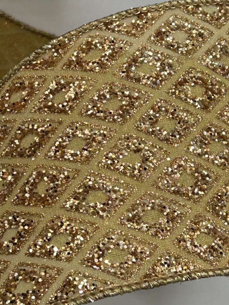 Puede incluir: Primer plano de una cinta dorada con un patr&oacute;n de diamantes. Los diamantes est&aacute;n llenos de purpurina dorada, creando un efecto brillante. La cinta tiene un aspecto texturizado y probablemente se utiliza para decoraci&oacute;n o manualidades.
