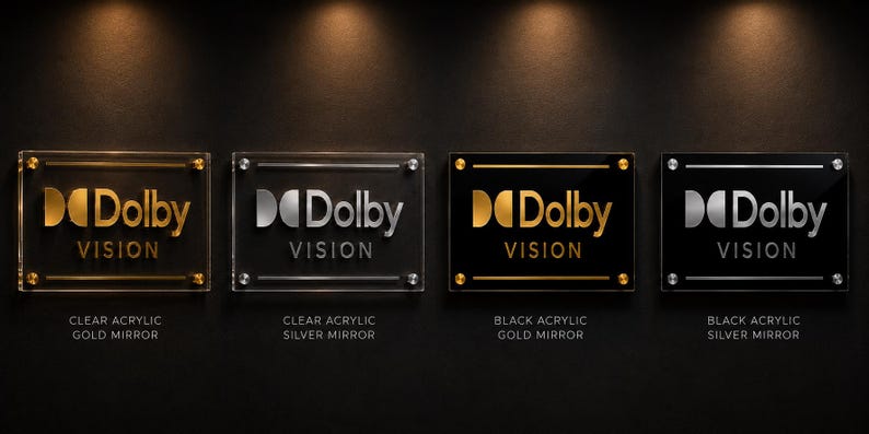 K&ouml;nnte beinhalten: Vier rechteckige Acrylschilder mit dem Dolby Vision Logo und Schriftzug. Zwei Schilder bestehen aus klarem Acryl mit goldener oder silberner Spiegelschrift, zwei aus schwarzem Acryl mit goldener oder silberner Spiegelschrift, montiert mit Metall.