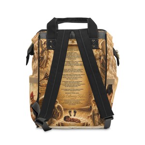 Op de afbeelding: Een rugzak met een goudkleurige religieuze print met engelen, wolken en de tekst "Behold your son, Rafe Calloway Kukula" en andere passages. De tas heeft zwarte schouderbanden, zwarte handvatten aan de bovenkant en zijvakken.
