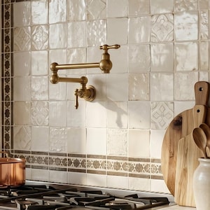 May include: A kitchen scene featuring a wall-mounted brass pot filler faucet above a gas stove with a copper pot. The backsplash consists of square off-white tiles with a decorative border. Wooden cutting boards and kitchen utensils are present.