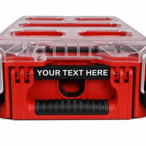 May include: A red and black storage organizer case with a clear plastic lid featuring multiple compartments. The front of the case includes a black rectangular label area with the white text YOUR TEXT HERE and a black textured handle.