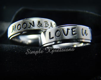 May include: Two silver rings with engraved text. The top ring says "LOVE U" and the bottom ring says "TO THE MOON & BACK".