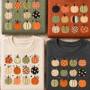 Könnte beinhalten: Vier Rundhals-Sweatshirts in Olivgrün, gebranntem Orange, Creme und Anthrazit. Jedes Kleidungsstück zeigt ein Raster aus zwölf illustrierten Kürbissen mit verschiedenen Mustern wie Blumen, Karos, Leopardenmuster und Punkten in saisonalen Farben.