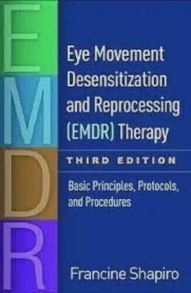 May include: A book cover with the title "Eye Movement Desensitization and Reprocessing (EMDR) Therapy" by Francine Shapiro. The cover has a blue background with the letters E, M, D, and R in green, blue, gold, and purple.