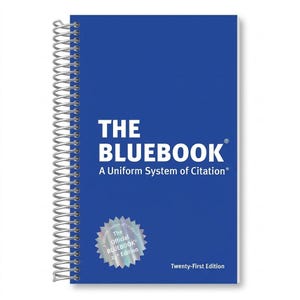 May include: A blue spiral-bound book titled "THE BLUEBOOK" with white text. The cover also includes the text "A Uniform System of Citation" and a silver sticker that reads "The Official BLUEBOOK 21st Edition". The words "Twenty-First Edition" are at the bottom.