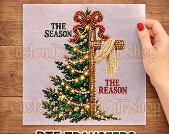 May include: A DTF transfer sheet featuring a split design of a green Christmas tree and a wooden cross. The tree is decorated with pearls and lights, topped with a red bow. The cross is draped with a pearl garland. Text reads: READY TO PRESS, THE SEASON, THE REASON, DTF TRANSFERS.