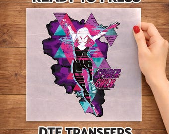 May include: A square DTF transfer sheet featuring a graphic of Spider-Gwen in a dynamic pose. The design includes purple, pink, and teal geometric shapes, a black and white suit, and the text Spider-Gwen. The words READY TO PRESS DTF TRANSFERS appear.