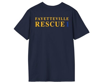 May include: A navy blue short-sleeve t-shirt featuring the text FAYETTEVILLE RESCUE 1 printed on the chest. The word FAYETTEVILLE is in yellow, the word RESCUE is in yellow, and the number 1 is in blue, all in a bold serif font.