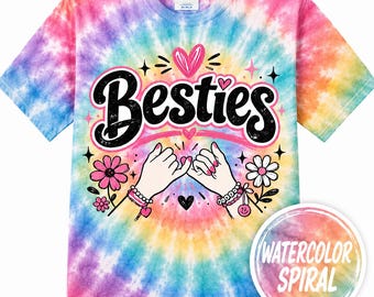 May include: A short-sleeve t-shirt with a multi-colored tie-dye spiral pattern in pink, blue, and yellow. The center features the word Besties in black script, a pink heart, and an illustration of two hands making a pinky promise with flowers.