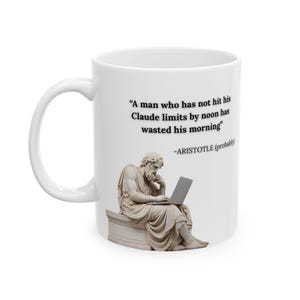 May include: A white ceramic mug featuring a printed illustration of a classical statue sitting and using a laptop. The text reads: A man who has not hit his Claude limits by noon has wasted his morning -ARISTOTLE (probably).