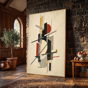 May include: A large rectangular framed wall art piece featuring a composition of geometric shapes including vertical bars, thin lines, and circles in a palette of black, cream, red, and yellow, set against a textured off-white background.