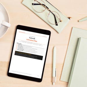 May include: A tablet displaying a document titled Network Activation Plan with sections for network audit, target contact list, outreach system, conversation guide, and follow up. Nearby are round gold-rimmed glasses, a mint green pen, and a notebook.