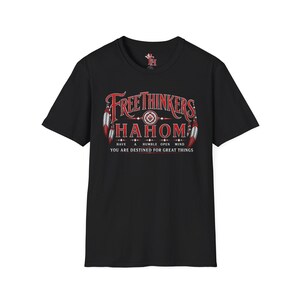 May include: A black short-sleeve t-shirt featuring a red and white graphic print. The text reads "FREETHINKERS HAHOM", "HAVE A HUMBLE OPEN MIND", and "YOU ARE DESTINED FOR GREAT THINGS". The design includes red and white feathers on the sides.