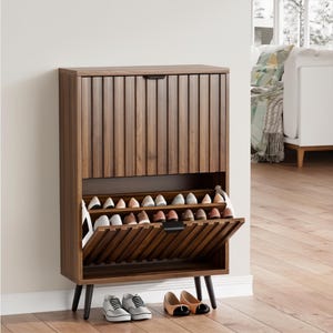 May include: A tall, rectangular wooden shoe cabinet with a dark walnut finish, featuring vertical slatted doors and black tapered legs. The cabinet has two drop-down compartments, one of which is open, revealing rows of stored footwear.