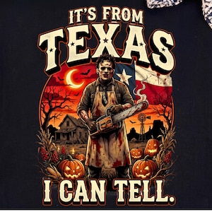 May include: A black t-shirt featuring a graphic print of a masked figure in a blood-stained apron holding a chainsaw. The design includes the text IT'S FROM TEXAS I CAN TELL, a Texas flag, a crescent moon, a house, and several carved pumpkins.