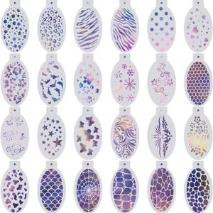 Könnte beinhalten: Ein Set aus zwanzig ovalen Schablonen mit verschiedenen ausgeschnittenen Mustern, darunter Tiermotive, geometrische Formen, Blumen, Sterne, Schmetterlinge, Schneeflocken und ein Spinnennetz, jeweils mit einem Loch an der Oberseite.