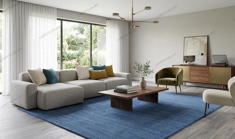 Solid blue hand-tufted wool rectangular area rug with medium Loop pile on wood flooring in a minimalist living room setting.