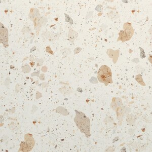 May include: A flat surface featuring a terrazzo pattern with an off-white base colour. The design consists of scattered, irregular stone-like fragments in various shades of tan, beige, light brown, and soft grey, creating a speckled appearance.