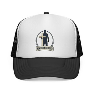 Può includere: Cappellino da camionista bianco e nero con visiera curva. Il pannello frontale bianco presenta un logo circolare di una persona che tiene una croce, con la scritta "KINGDOM BUILDER" sotto.