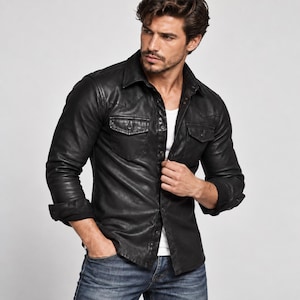 Puede incluir: Una camisa negra de manga larga con botones, cuello en punta, dos bolsillos en el pecho con solapas y acabado liso. La camisa se lleva sobre una camiseta interior blanca lisa y se combina con vaqueros azules, con un corte y puños estándar.