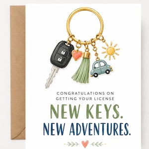 May include: A greeting card featuring a gold keyring with a car key fob, a red heart charm, a sage green tassel, a blue car charm, and a yellow sun charm. The text reads: CONGRATULATIONS ON GETTING YOUR LICENSE. NEW KEYS. NEW ADVENTURES.