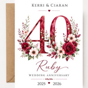 May include: A white anniversary card featuring the text Kerri & Ciaran at the top, a large watercolor number 40 in deep red, surrounded by floral arrangements of red roses and white flowers, with the text Ruby Wedding Anniversary and 2025 2026.