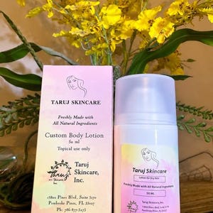 Puede incluir: Una botella de loción blanca y una caja de loción corporal personalizada de Taruj Skincare. La loción es para pieles secas y está elaborada con ingredientes totalmente naturales. La caja y la botella tienen una etiqueta rosa y amarilla con el logotipo y la información de contacto de la marca.
