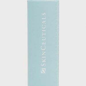 Op de afbeelding: Een lichtblauwe rechthoekige doos met de witte tekst "SkinCeuticals". De doos heeft een liniaalachtig ontwerp aan de rechterkant. De productverpakking is effen lichtblauw.