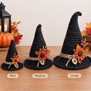 Peut inclure: Trois chapeaux de sorcière en crochet noir de tailles mini, moyenne et grande. Chaque chapeau présente une bande en corde de jute, un petit tournesol orange, des feuilles aux couleurs automnales et un bouton en bois en forme de feuille.