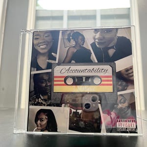 Puede incluir: Una caja de CD de plástico transparente con un collage de fotografías en blanco y negro de una persona. En el centro hay un gráfico de un casete con la palabra Accountability en cursiva y una etiqueta de Parental Advisory Explicit Content.