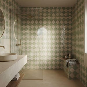 May include: A bathroom featuring walls covered in a green and white diamond-patterned tile design. The space includes a round vessel sink on a stone vanity, a circular backlit mirror, a glass-enclosed shower with gold fixtures, and a tiled bench.